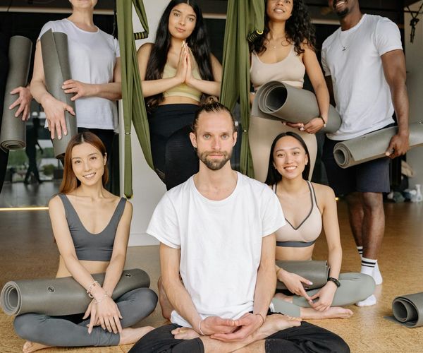 Group of women of different ages smiling during a yoga class.
